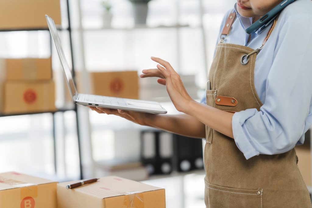 Employee holding laptop in shipping station