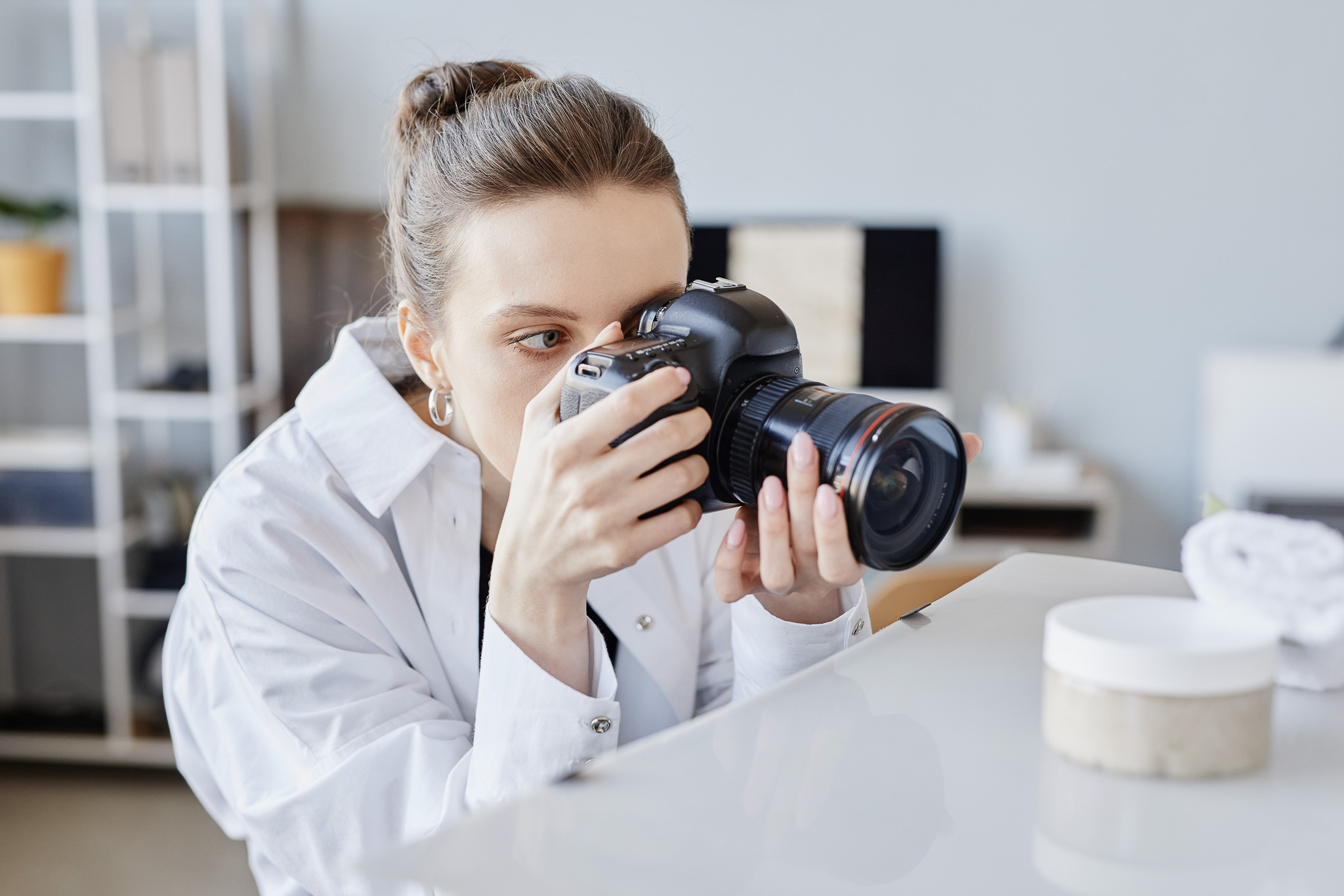 Side View Portrait of Young Woman Taking Product Images of Handmade pottery
