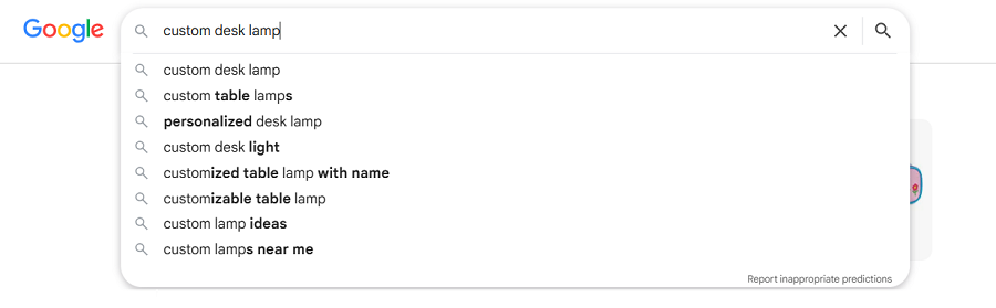Google dropdown menu listing eight suggestions related to the search "custom desk lamp."